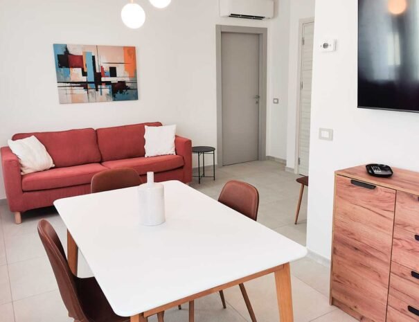 Angolo relax nel soggiorno dell'appartamento Alba con comodo divano ideale per i momenti di riposo e lettura