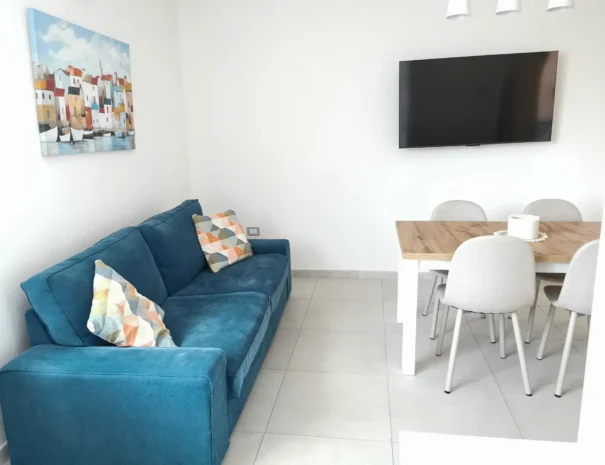 Interno del soggiorno con dettagli divano dell'appartamento Soli a Teulada.