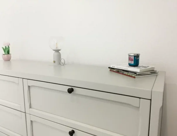 Dettaglio dell'arredo moderno nella camera matrimoniale di Domus Luna, con cassettiera coordinata e finiture di pregio in un ambiente luminoso.