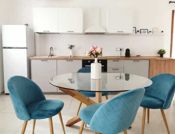 Cucina completa di Domus Luna con piano cottura, forno, ampi ripiani in legno e tavolo da pranzo, ideale per soggiorni lunghi e self-catering.