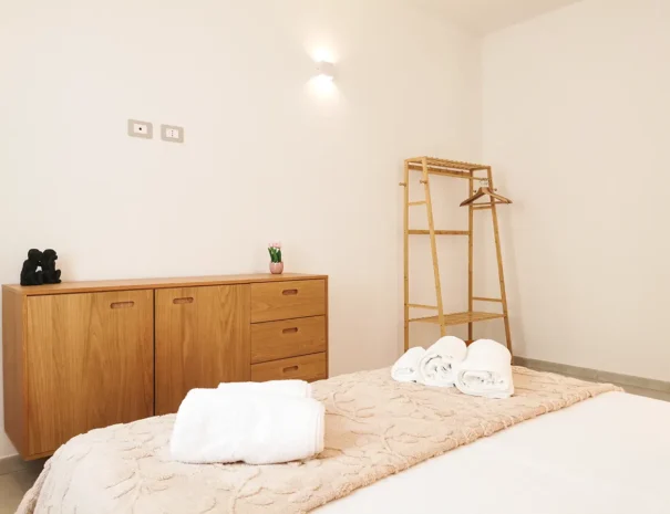 Mobili e cassettiera in legno nella zona notte dell'appartamento Domus Luxi.