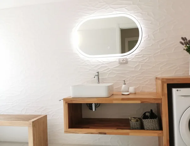 Dettaglio del lavabo e specchio retroilluminato a LED nel bagno a Teulada