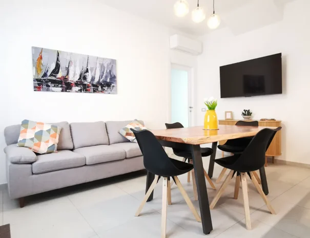 Area living luminosa con televisore e arredi contemporanei a Teulada.